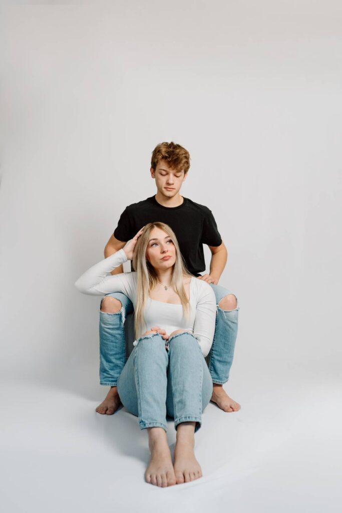 serious pose with couples while girl sits on floor and he sits higher behind her