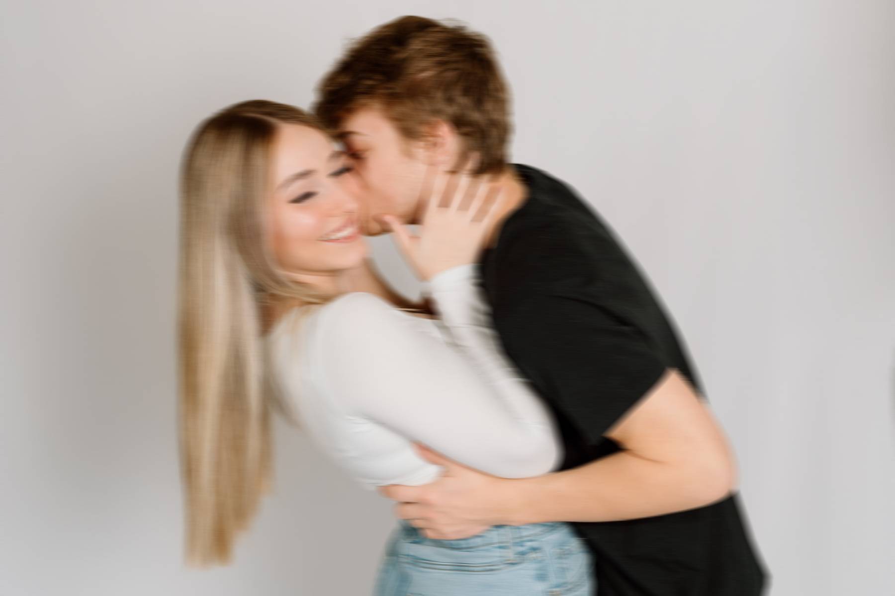 man kissing girl on cheek blurry picture with movement