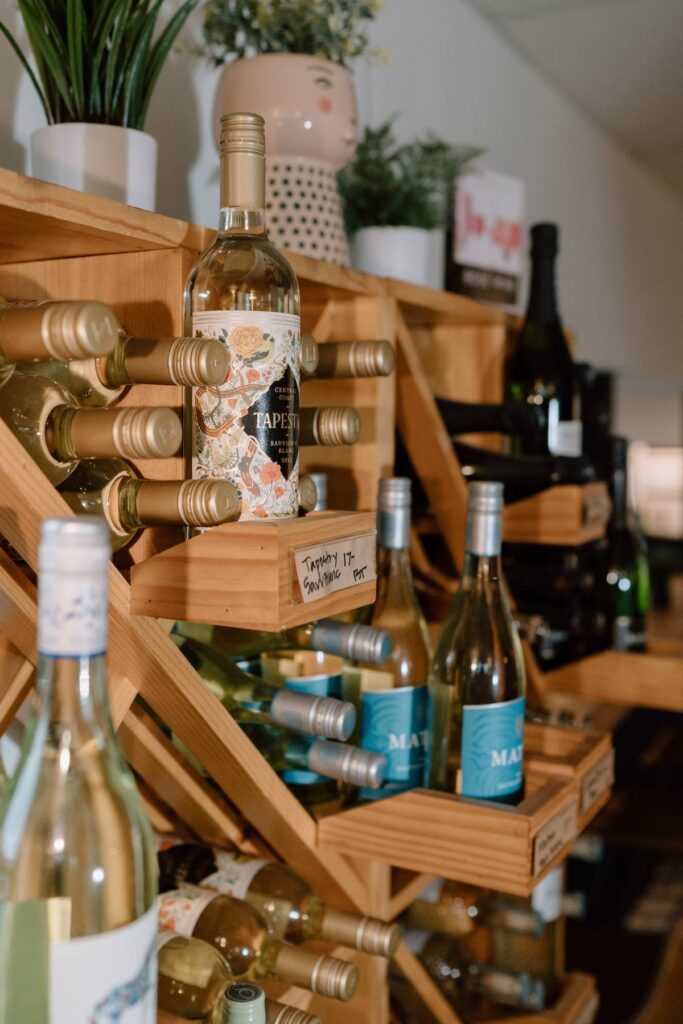 wooden rack showcasing wine being sold at a coffee shop