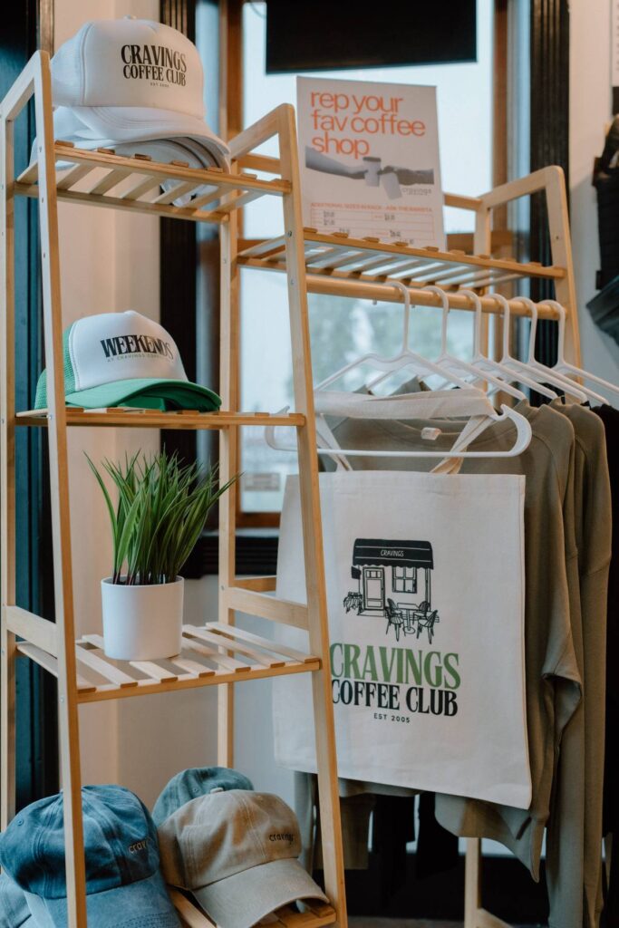 items available for purchase at a coffee shop like hats, bags, and shirts