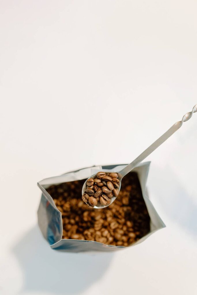 product photography of espresso beans with a spoon holding a few outside of the frame