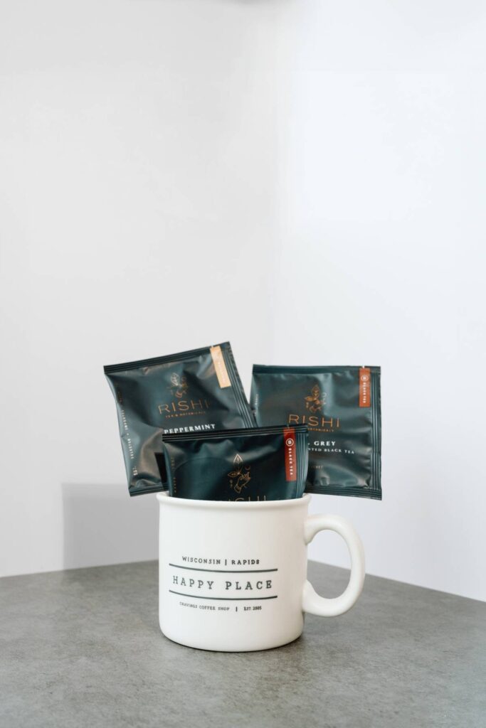 detail photograph of private labeled coffee mug with coffee and tea bags sticking out