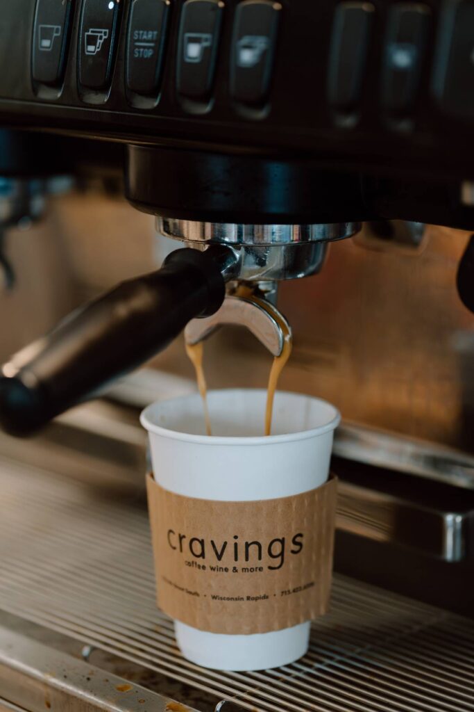 coffee cup being utilized for the pouring of the espresso being made at a coffee shop