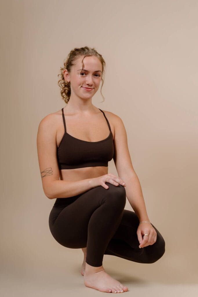 one knee on ground other up smiling at the camera