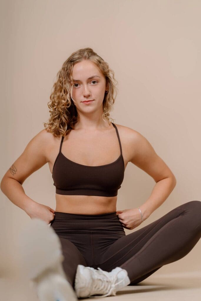 Studio Portraits for Branding Photography, picture of client doing a stretching pose in a workout set