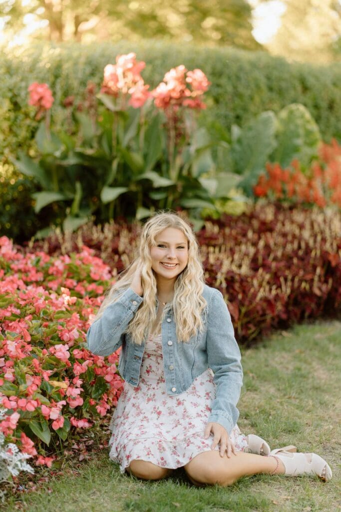 Kalea sitting on a bench surrounded by vibrant flowers in Milwaukee.
