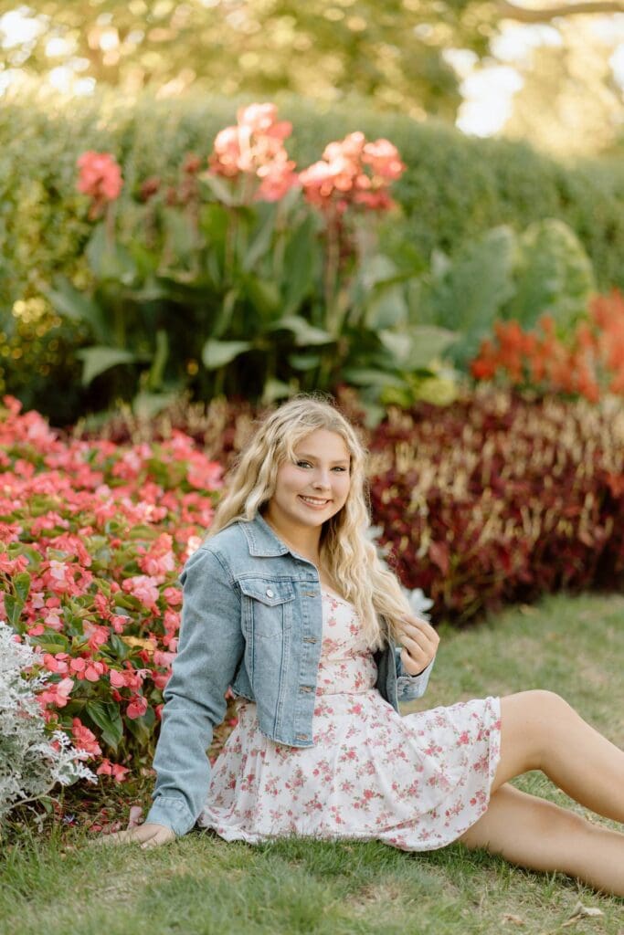 Senior photo of Kalea smiling in front of blooming flowers.