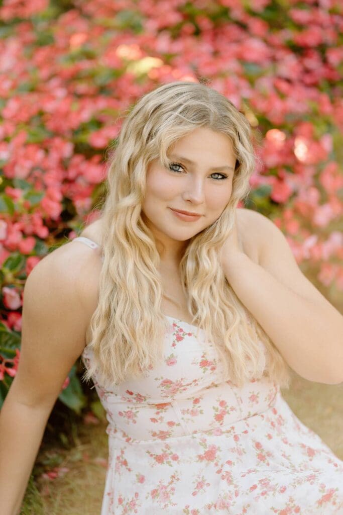 Kalea posing in a flower garden in Milwaukee wearing a floral dress.