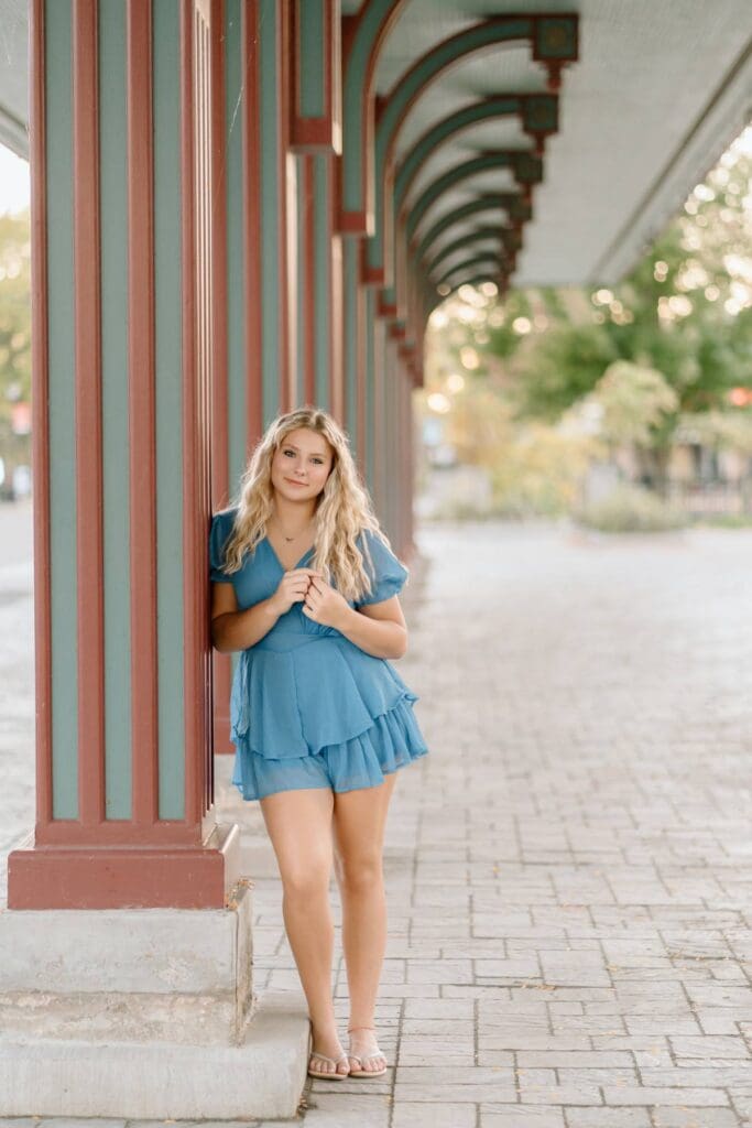 Kalea walking down a street in downtown Milwaukee during her senior photo session.