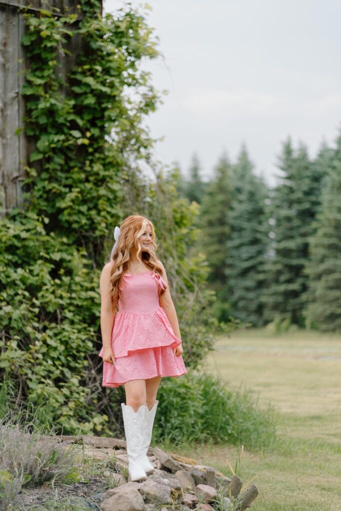 Waupaca senior girl smiling while leaning against a wooden fence